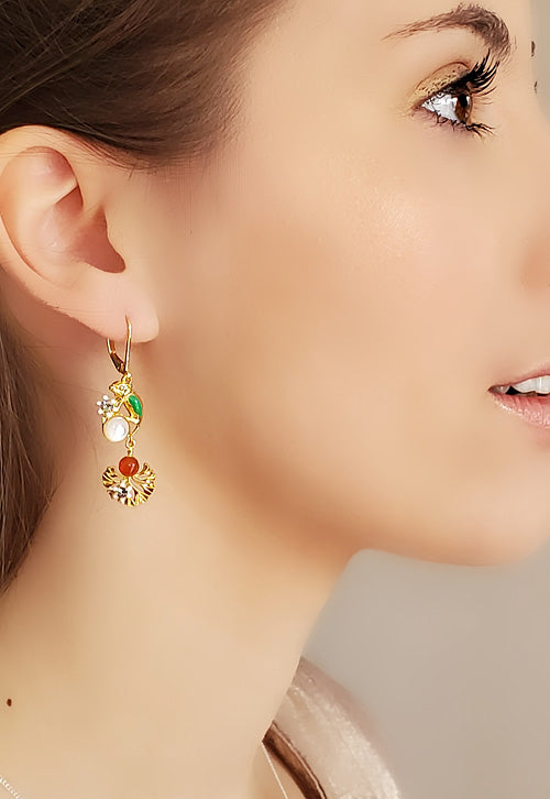 Boucles d'oreilles pendantes dorées à l'or fin 24 carats. motifs caméléon et fleur émaillées, cabochons en nacre et cornaline, strass Swarovski. Longueur 4,5 cm environ.