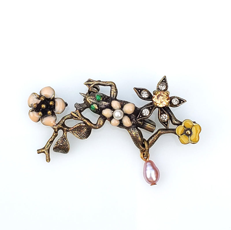 broche grenouille en métal bronze patiné, fleurs émaillées rose et ocre, une fleur en strass Swarovski, perle d'eau douce rose et petite perle blanche.  Modifier le texte alternatif