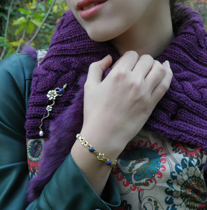 Une parure réussie avec le bracelet gourmette Flora lapis et la broche serpent assortie.
