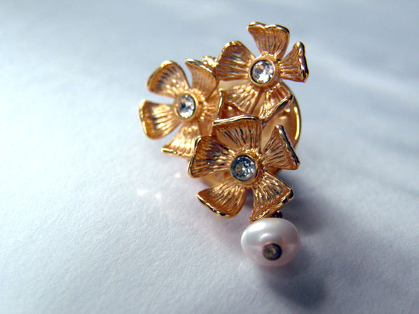 Broche fleurs en métal doré à l'or fin, pétales gravés, cristaux Swarovski au centre de chacune des trois petites fleurs, perle d'eau douce blanche pendante. Style rétro.