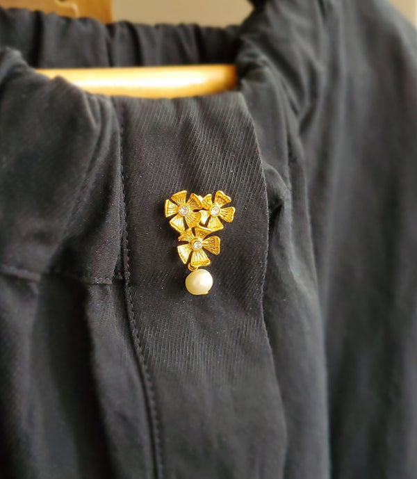 Broche pin composée de trois fleurs gravées, dorée à l'or fin, cristaux Swarovski, perle d'eau douce en papille.