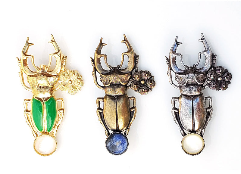 3 versions, 3 finitions pour cette broche scarabée en métal et pierre fine.