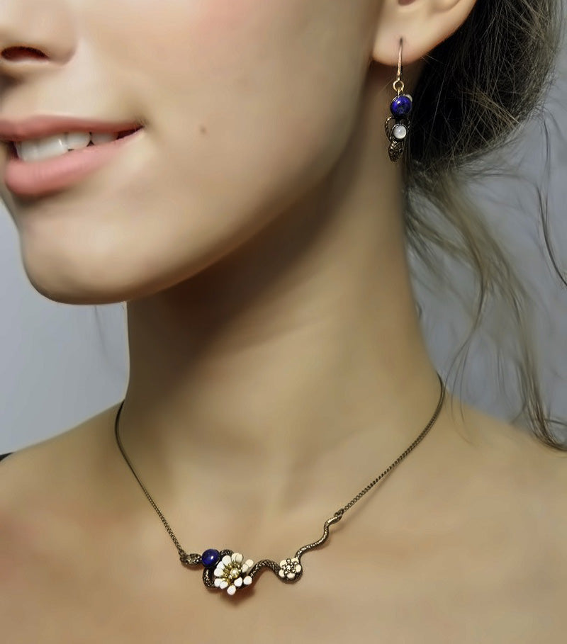 collier ras de cou serpent et marguerite blanche, à associer aux boucles d'oreilles serpent Eden en lapis lazuli.